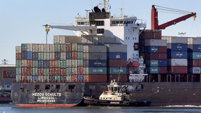 A container ship is pushed to its berth by a tug at the Port of Melbourne. Picture: AFP PHOTO / William WEST