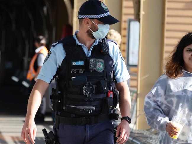 Police have been seen questioning people for suspected Covid breaches at Broadmeadow train station in Newcastle today. Particularly trains arriving from Sydney. This policeman asked the girl to put on a mask. Picture: David Swift