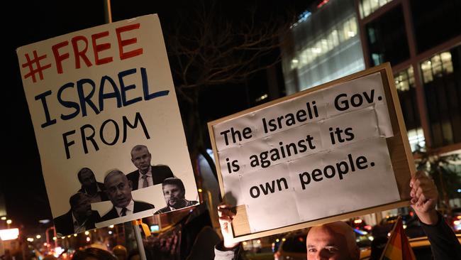 Protesters lift placards during an anti-government demonstration in Israel's central city of Tel Aviv, on February 17, 2024, amid the ongoing conflict in the Gaza Strip between Israel and the Palestinian militant Hamas movement. (Photo by JACK GUEZ / AFP)