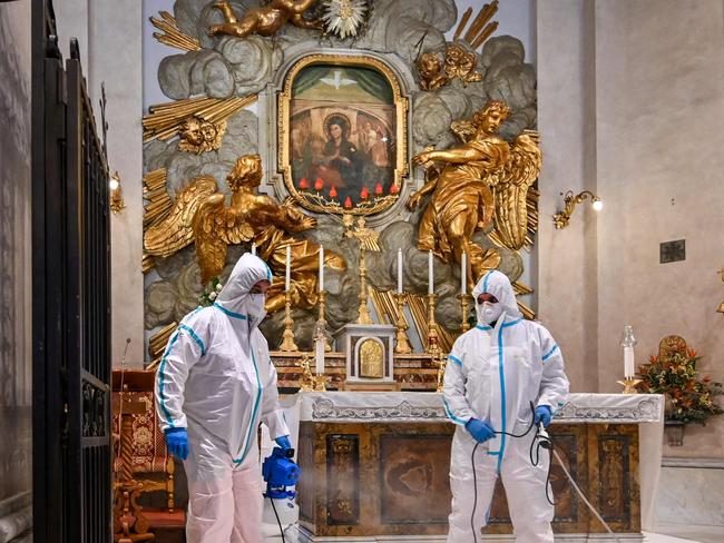 Two workers sanitise the Santuario della Madonna del Divino Amore church in Rome. Picture: Andreas Solaro/AFP