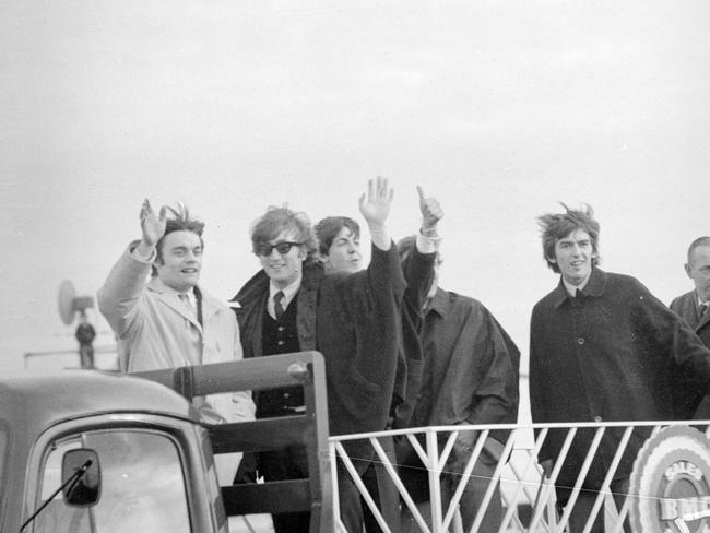 June 14, 1964: The Beatles and fill-in drummer Jimmie Nicol were put on a flat-bed truck so they could wave to the thousands of fans waiting to greet them at Essendon Airport. Picture: Herald Sun Image Library