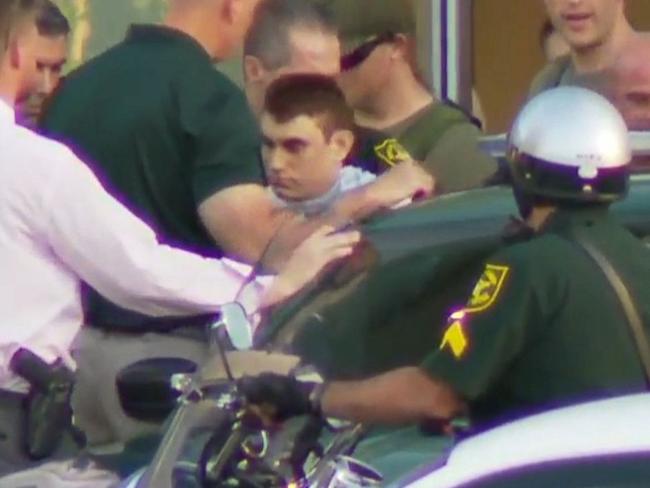 Nikolas Cruz, the suspect in a shooting at Marjory Stoneman Douglas High School in Parkland, Florida, is escorted out of a hospital and into a police car. Picture: Supplied