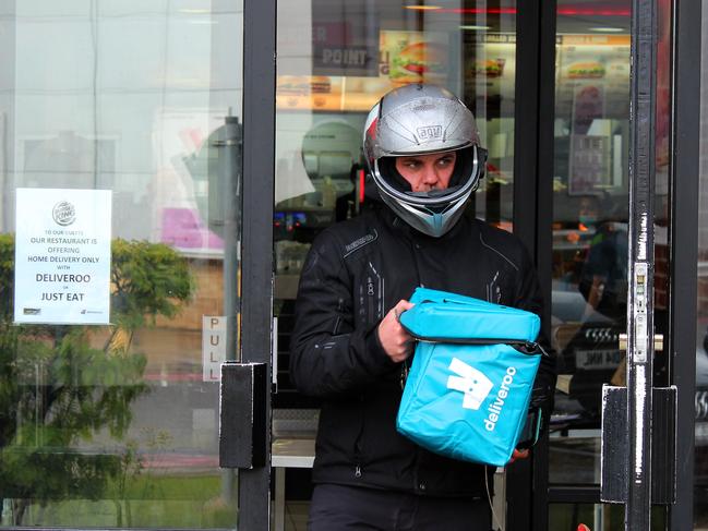 A Deliveroo driver collects a food order from a re-opened Burger King restaurant. (Photo by Mark Trowbridge/Getty Images)