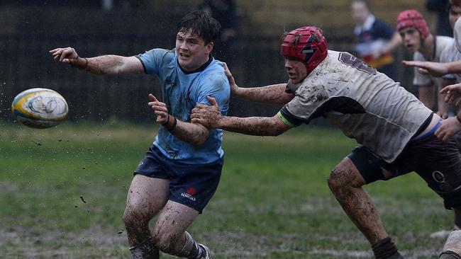 NSW's Nick Lamming with the ball caught by Queensland's Connor Dick.