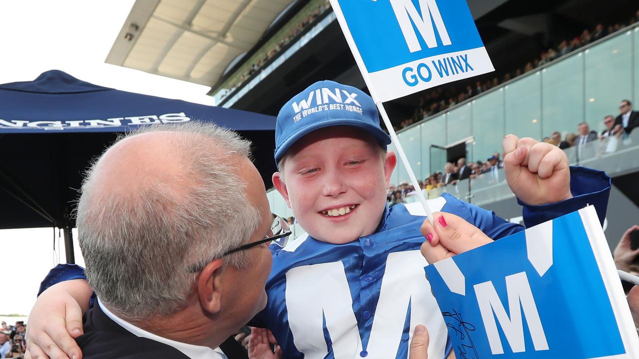 Scott Morrison celebrated the Winx win with high fives to the crowd and hugging an emotional Lewis McCombe, 10 years old. Picture Gary Ramage