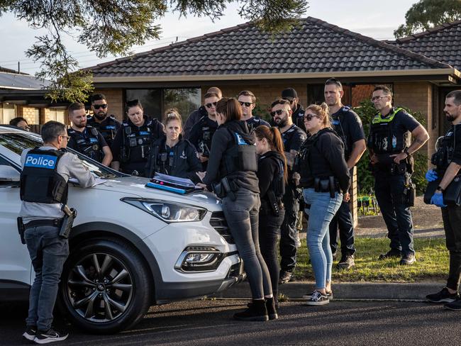 Police conduct a briefing before embarking on a raid. Picture: Jake Nowakowski