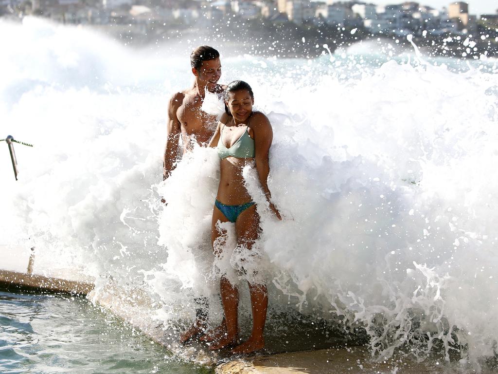 Pictured is Tiara Quick and Cheyne Pearson having fun in the big waves crashing over Bronte Pool. Picture: Tim Hunter