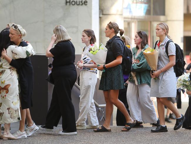 Students return to the school for the first time, bringing flowers. Picture: Rohan Kelly