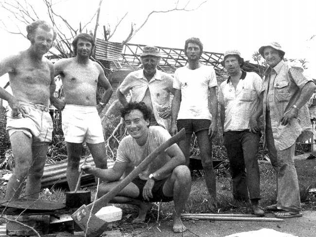 Journalists & photographers after Cyclone Tracy hit on Christmas day 1974 (crouching) journalist Kim Lockwood, & photographer Bruce Howard (far left) with friends in remains of Lockwood's backyard 3 days after it hit. 28/12/74         General           Northern Territory / Weather / Cyclones / Storms