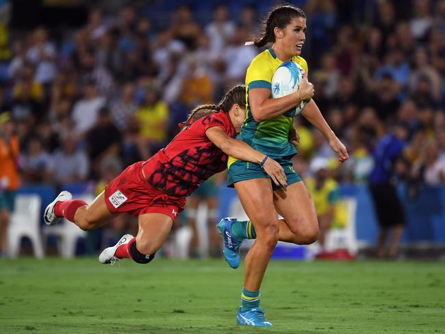 CORRECTION - Australia's Charlotte Caslick (R) is tackled on the tryline by Jasmine Joyce of Wales (L) in the women's rugby sevens match during the 2018 Gold Coast Commonwealth Games at the Robina Stadium on the Gold Coast on April 13, 2018. / AFP PHOTO / WILLIAM WEST / “The erroneous mention[s] appearing in the metadata of this photo by WILLIAM WEST has been modified in AFP systems in the following manner: [Jasmine Joyce ] instead of [Shannon Parry]. Please immediately remove the erroneous mention[s] from all your online services and delete it (them) from your servers. If you have been authorized by AFP to distribute it (them) to third parties, please ensure that the same actions are carried out by them. Failure to promptly comply with these instructions will entail liability on your part for any continued or post notification usage. Therefore we thank you very much for all your attention and prompt action. We are sorry for the inconvenience this notification may cause and remain at your disposal for any further information you may require.”