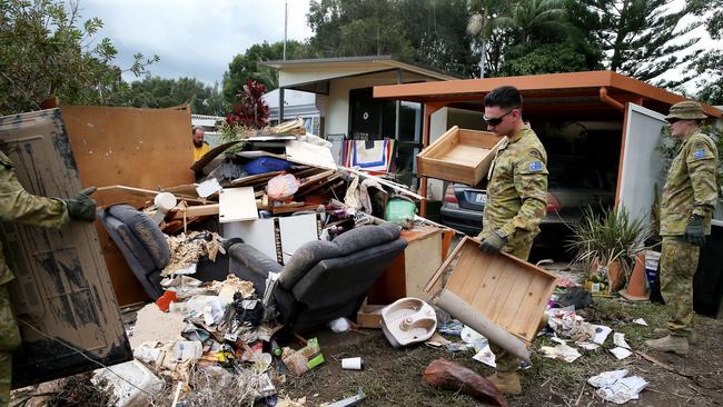 An army of volunteers from the ADF’s 6th Battalion RAR from Brisbane help clean up at the Riverside Village Residential Park on Hastings River Drive at Port Macquarie. Picture: Nathan Edwards