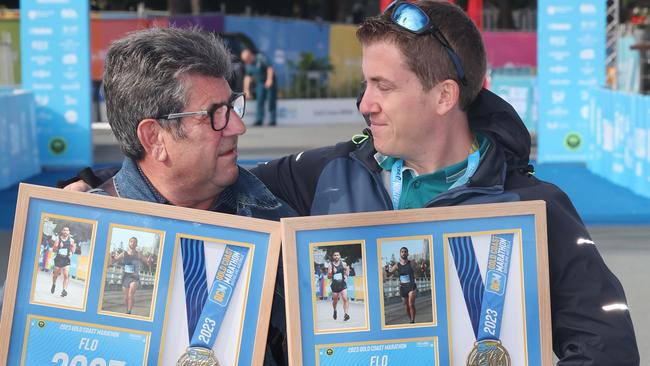 Jean-Luc Gallay (father) and Yvan Gallay (brother), hold the photo tributes presented to them at the spot where French marathon entrant Florian Gallay died on course last year at the Gold Coast marathon. Picture Glenn Hampson