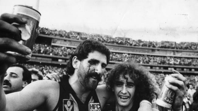 In May, the MCG in Melbourne embarked on a trial to reintroduce beer cans for sale in certain areas of the ground. The move harks back to the old days in the VFL when fans and players alike celebrated a win with a can. Footballer Robert DiPierdomenico and John Platten celebrating the 1986 Grand Final at the MCG. Picture: Stuart Hannagan