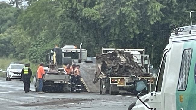 Police and tow truck operators work at the scene of the two-vehicle highway crash that also resulted in a vehicle fire at Glenella. Photo: Fergus Gregg