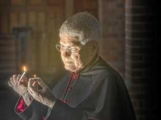 Reverened Canon Dr Gregory Jenks, dean of the Christ Church Cathedral in Grafton lights a candle in preparation for the vigil service to be held in the church. Picture: Adam Hourigan