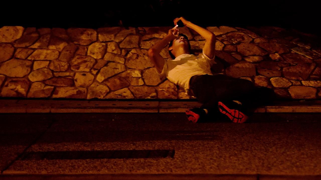 A New Year's Eve reveller takes a breather against a rock wall on Mitchell Street in the early hours of New Year's day