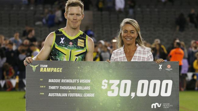 Jack Riewoldt presents the CEO of Maddie Riewoldt's Vision with a cheque for $30,000.