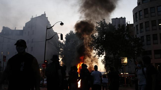 Protesters stand by a fire during a demonstration in Paris where riot officers fired tear gas.