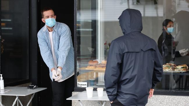 Staff at an Auckland cafe serve takeaway customers. Picture: Getty Images