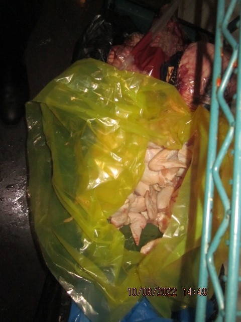 Raw chicken wings were seen stored uncovered.