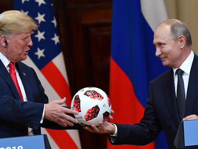 TOPSHOT - Russia's President Vladimir Putin (R) offers a ball of the 2018 football World Cup to US President Donald Trump during a joint press conference after a meeting at the Presidential Palace in Helsinki, on July 16, 2018. The US and Russian leaders opened an historic summit in Helsinki, with Donald Trump promising an "extraordinary relationship" and Vladimir Putin saying it was high time to thrash out disputes around the world.  / AFP PHOTO / Yuri KADOBNOV