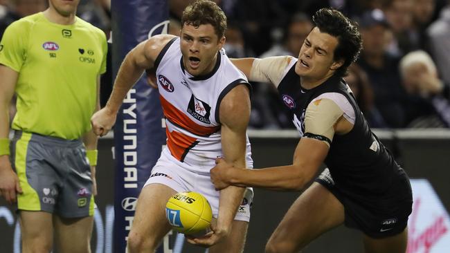 Heath Shaw clears just before Jack Silvagni tackles. Picture: Michael Klein