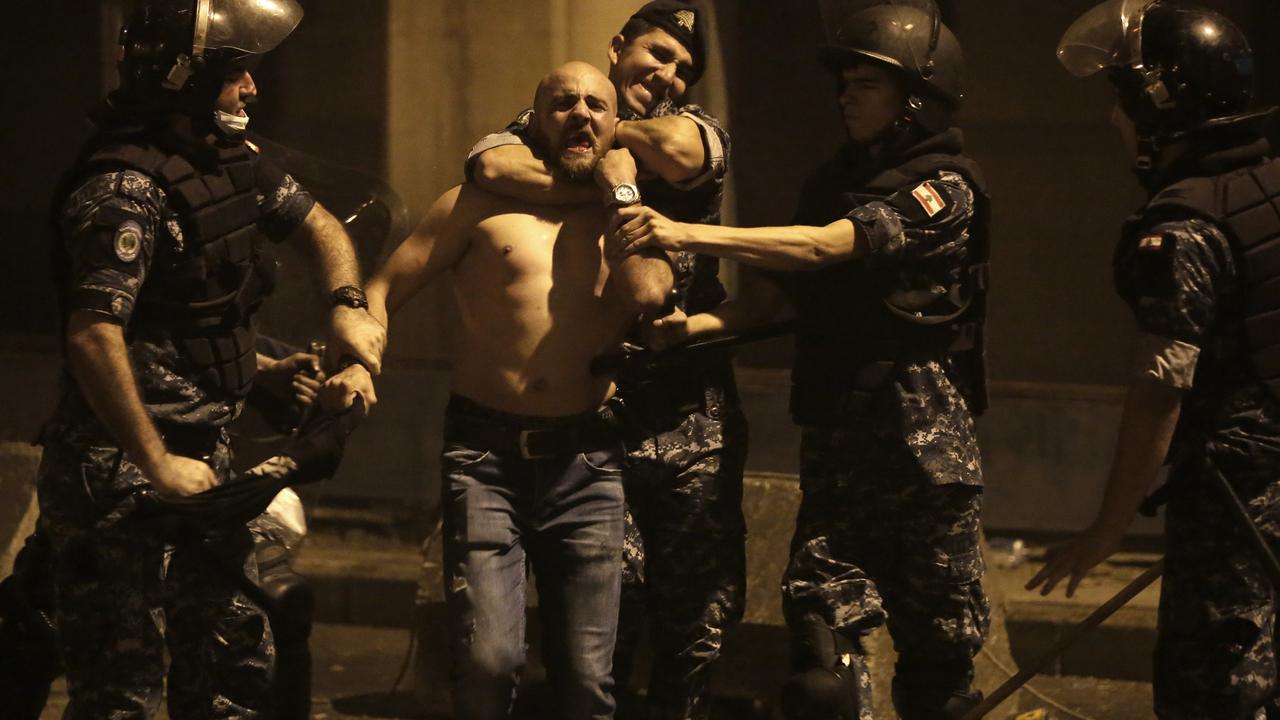 Riot police detain an anti-government protester during the demonstrations. Photo: Hassan Ammar/AP