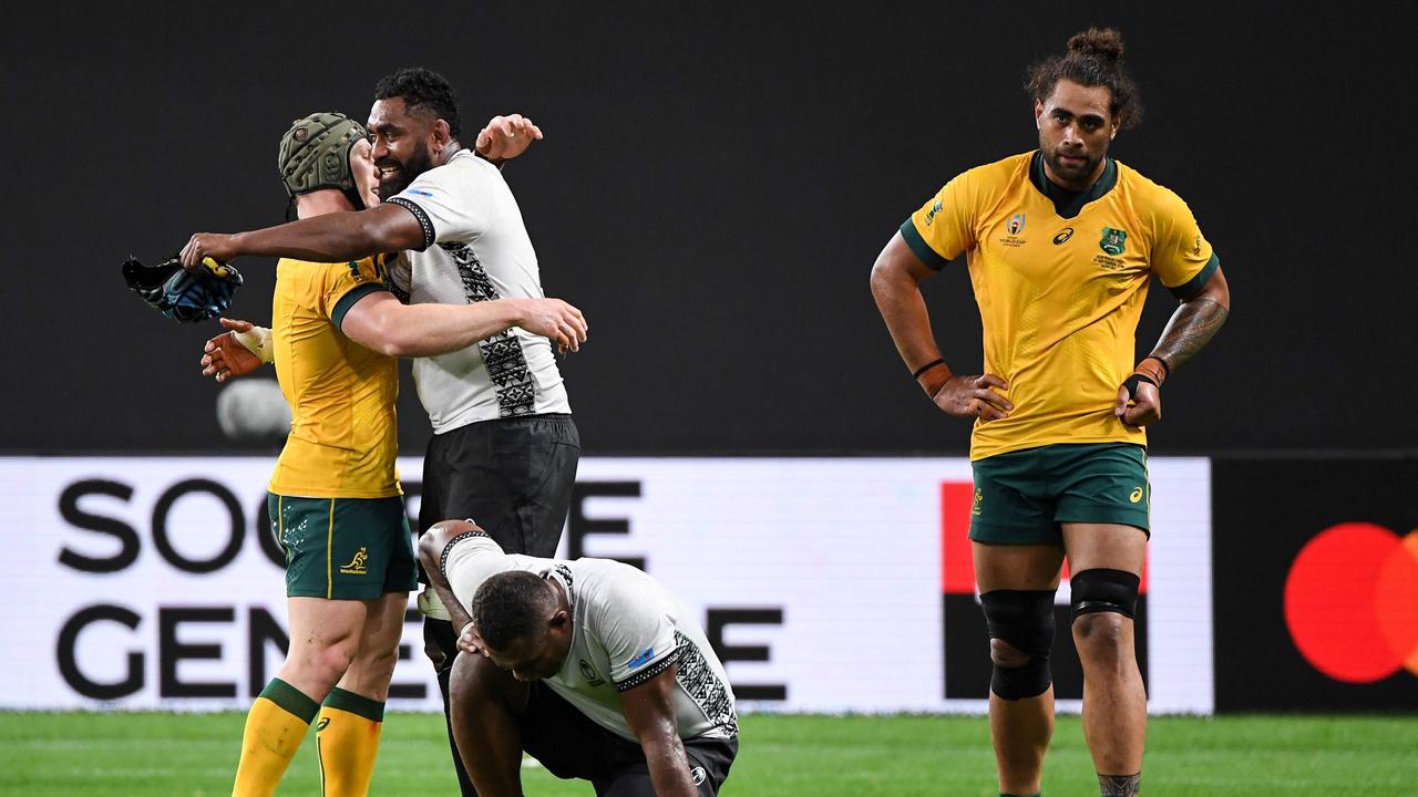 David Pocock (L) hugs Fiji's Tevita Cavubati after the Wallabies claimed victory. (Photo by WILLIAM WEST / AFP)