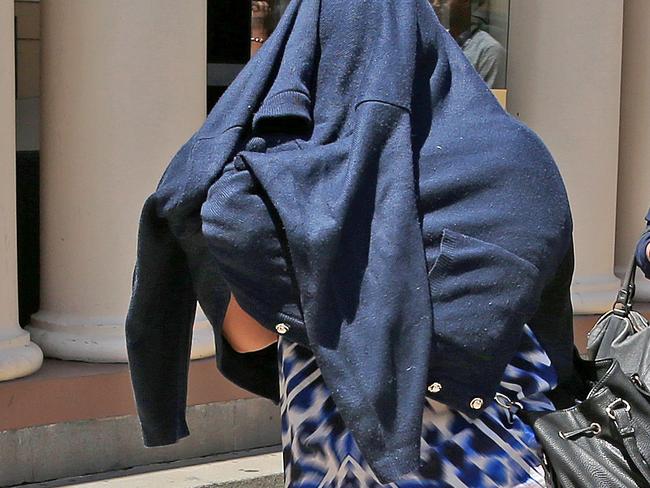 Peta-Ann Francis, mother of murdered toddler Nikki Francis-Coslovich, covers herself as she leaves court. Picture: Mark Stewart