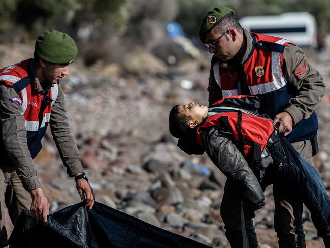 EDITORS NOTE: Graphic content: A Turkish gendarme carries the body of a migrant child on beach in Canakkale’s Bademli district on January 30, 2016 after at least 33 migrants drowned when their boat sank in the Aegean Sea while trying to cross from Turkey to Greece, Turkey’s state-run Anatolia news agency reported. Picture: AFP PHOTO / OZAN KOSE