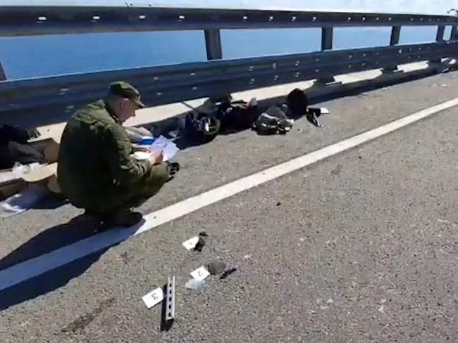 This video grab shows Russian committee investigators working on the Kerch bridge after the attack. Picture: Russian Investigative Committee/AFP