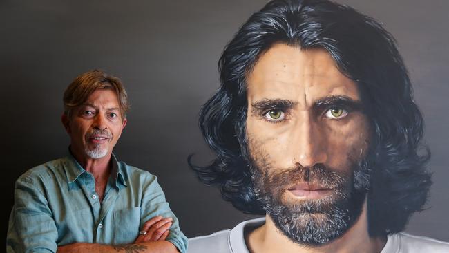 Artist Angus McDonald with his portrait of Behrouz Boochani at the Art Gallery of NSW in Sydney. Picture: Gaye Gerard