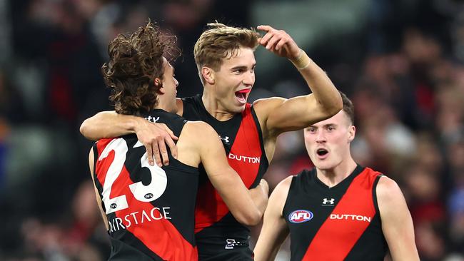 MELBOURNE, AUSTRALIA - JULY 05: Matt Guelfi of the Bombers is congratulated by team mates after kicking a goal during the round 17 AFL match between Collingwood Magpies and Essendon Bombers at Melbourne Cricket Ground, on July 05, 2024, in Melbourne, Australia. (Photo by Quinn Rooney/Getty Images)