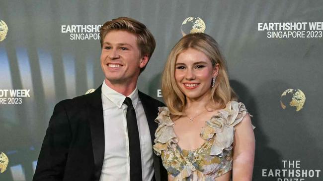 Australian wildlife conservationist Robert Irwin (L) and his girlfriend Rorie Buckey (R) pose as they arrive to attend the 2023 Earthshot Prize in Singapore on November 7, 2023. The Prince of Wales will unveil the five winners of the 2023 Prize that aims to reward innovative efforts to combat climate change. (Photo by MOHD RASFAN / AFP)