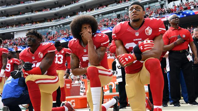 Eli Harold, Colin Kaepernick and Eric Reid of the San Francisco 49ers kneel on the sideline during the US national anthem in 2016.  Picture: Getty Images)