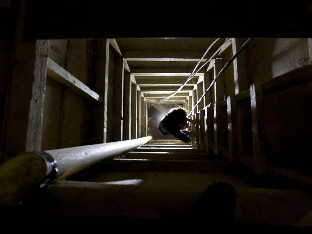 A journalist climbs a ladder to get out of underground tunnel Guzman used in his prison cell. He allegedly transported piles of cocaine through similar ones leading from Mexico to Arizona. Picture: AP Photo/Eduardo Verdugo