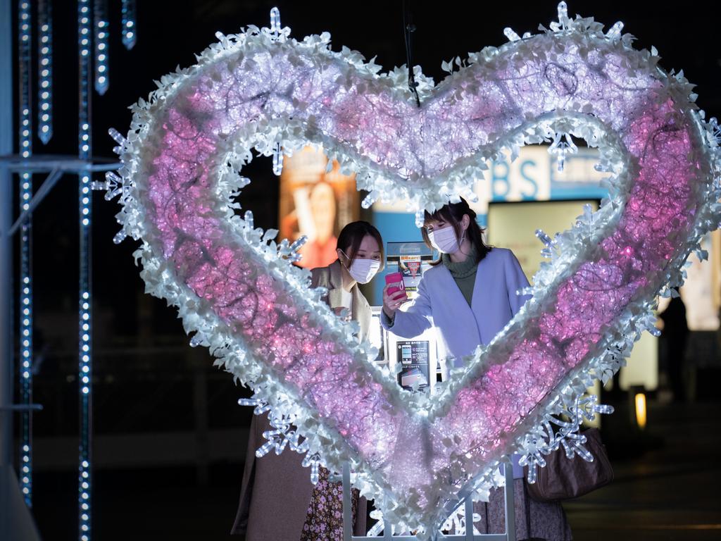 Women take a selfie next to a Christmas display in Tokyo. Picture: Carl Court/Getty Images