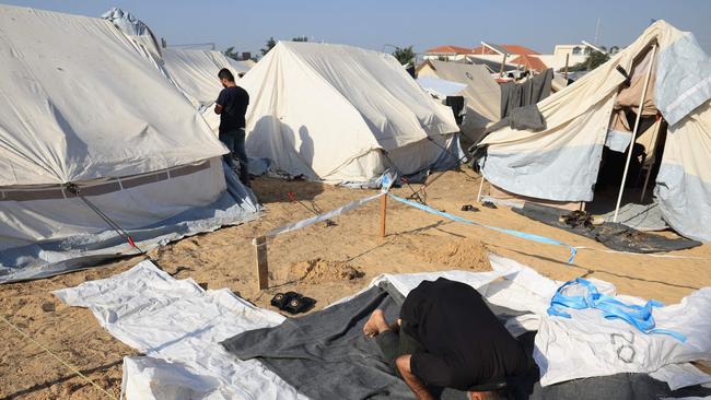 A man kneels to pray between tents at a makeshift camp for displaced people in Khan Yunis in the southern Gaza Strip. Photo: Mahmud HAMS / AFP