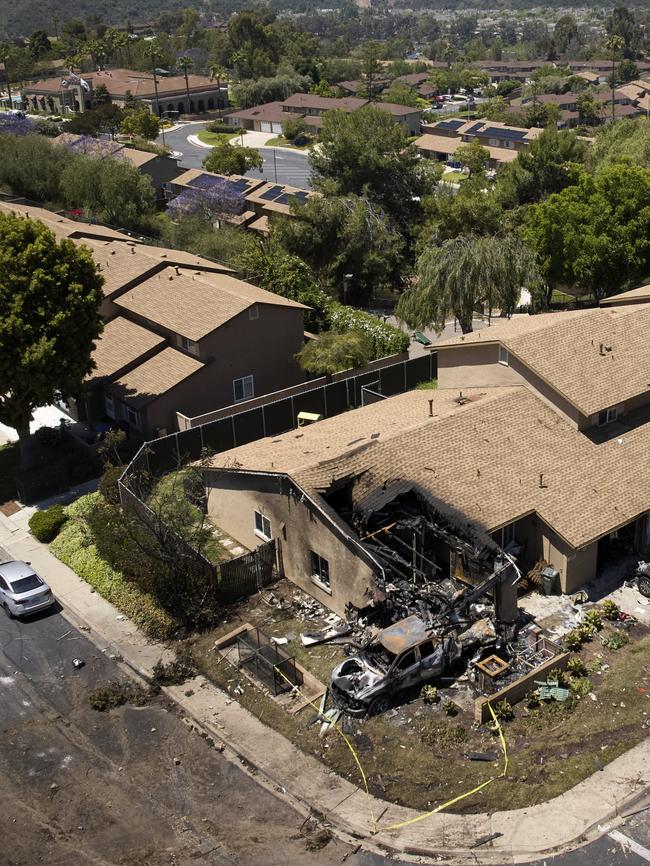 Debris covers the ground after a small plane crashed into a San Diego neighborhood, setting homes and cars on fire. Picture: AP Photo
