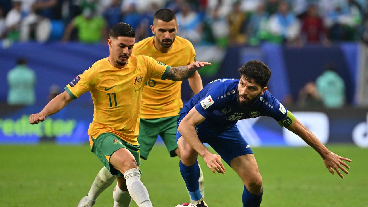 Marco Tilio (left) battles with Uzbekistan's Jaloliddin Masharipov at the Asian Cup. Picture: Hector Retamal/ AFP