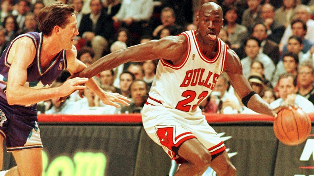 Former Chicago Bulls player Michael Jordan sticks out his tongue as he goes past Jeff Hornacek of the Utah Jazz during an NBA game in 1997. Picture: AFP