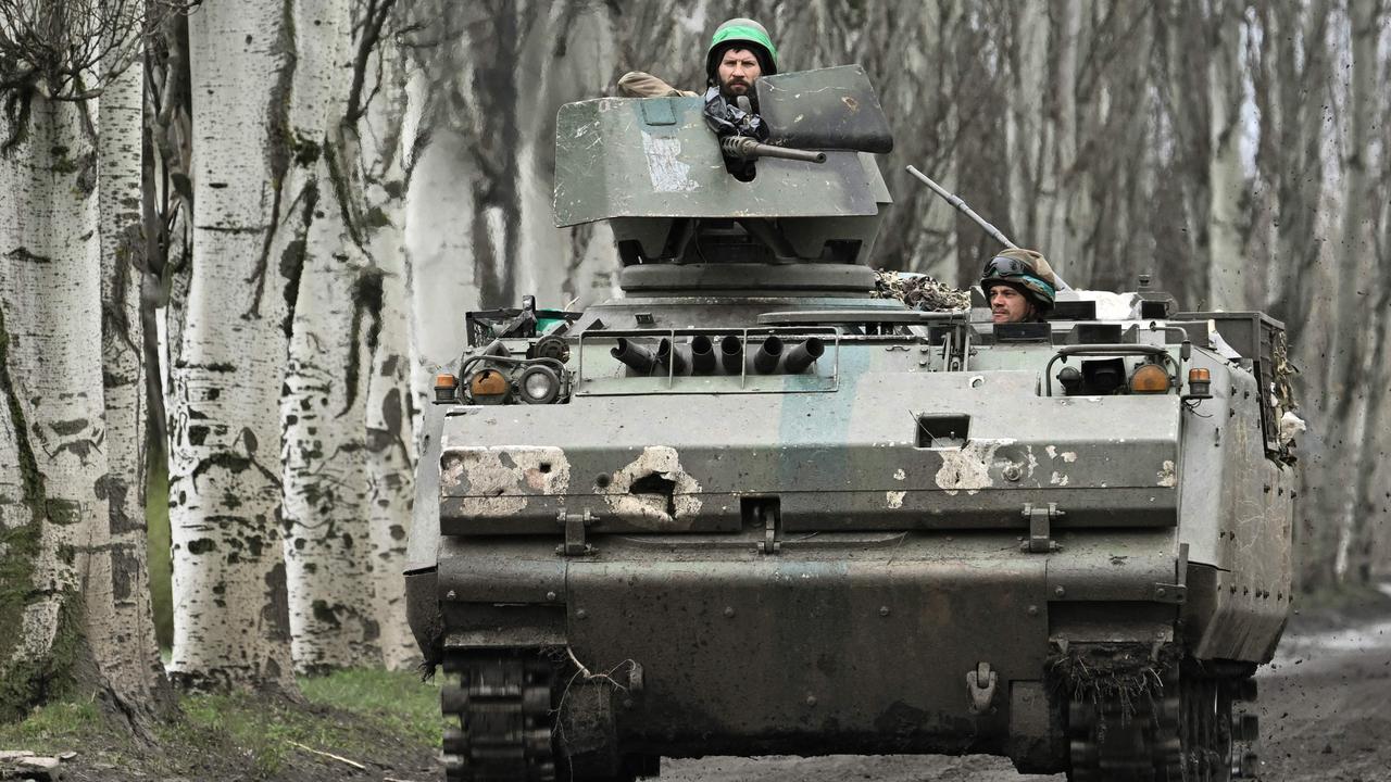 Ukrainian servicemen ride on Dutch YPR-765 armoured personnel carrier (APC) on a road near Bakhmut, Donetsk region. Picture: AFP.