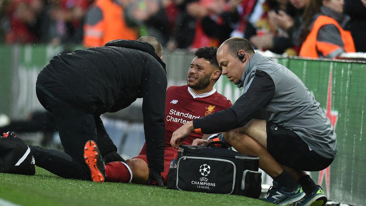 Alex Oxlade-Chamberlain (C) is treated for his injury.