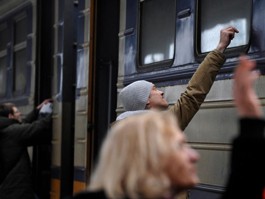 Men staying back in Ukraine farewell their loved ones as a train prepares to leave Kyiv station. Picture: AFP