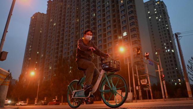 A man pedals a bike past a housing complex by Chinese property developer Evergrande in Beijing. Picture: AFP