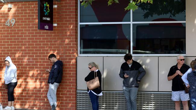 People queuing outside the Centrelink office at Norwood in late March, during the first wave of the coronavirus jobs crisis. Picture: Kelly Barnes/AAP