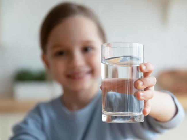 IStock generic of kids drinking -  Close up of happy little Caucasian girl offer crystal still mineral water for body refreshment, smiling small European child recommend daily dose of clean aqua, dehydration, healthy lifestyle concept