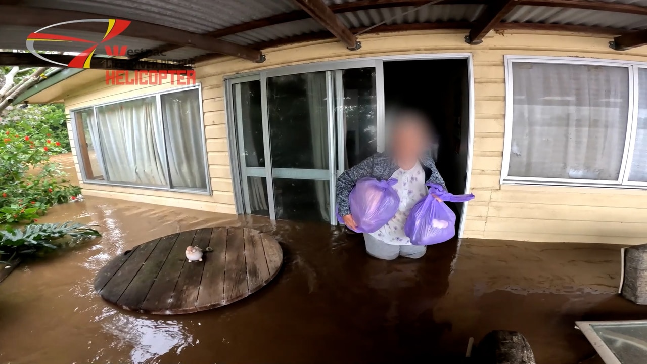 Dramatic vision of a woman being rescued from floods in Pampoolah by Westpac Chopper.