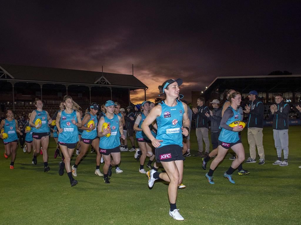 Angela Foley of Port Adelaide leads her team out through a guard of honour by the men’s AFL team during the first AFLW Port Adelaide training session at Alberton Oval. Picture Mark Brake