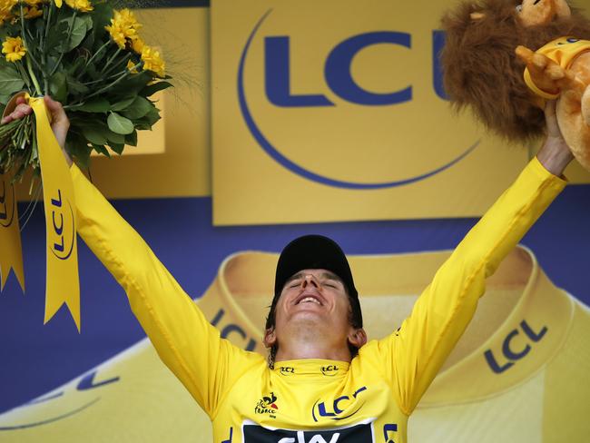 Britain's Geraint Thomas, wearing the overall leader's yellow jersey, celebrates on the podium after the twentieth stage of the Tour de France cycling race.